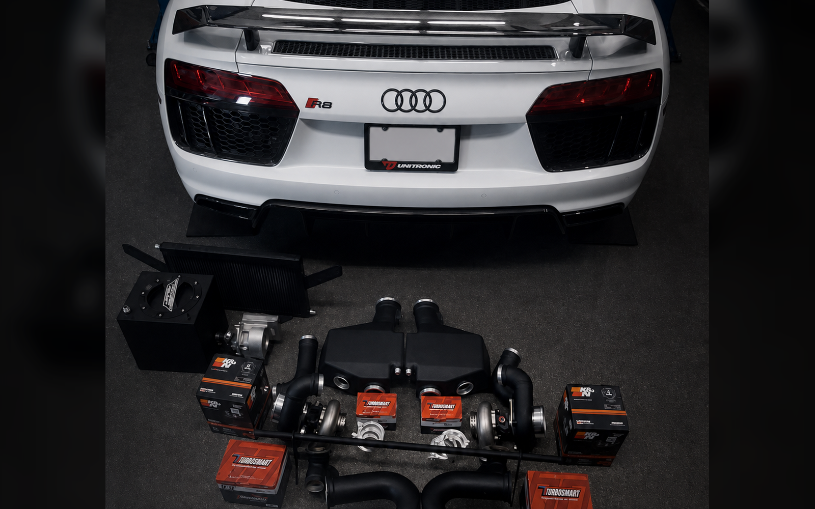 Audi R8 with supporting performance hardware laid out behind the car
